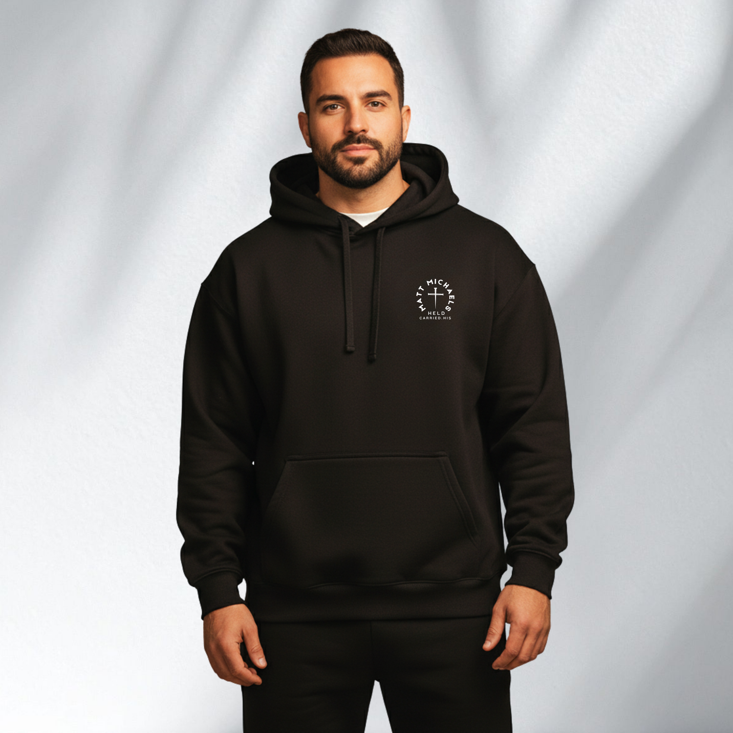Man wearing a black Matt Michaels hoodie with logo, mens streetwear collection