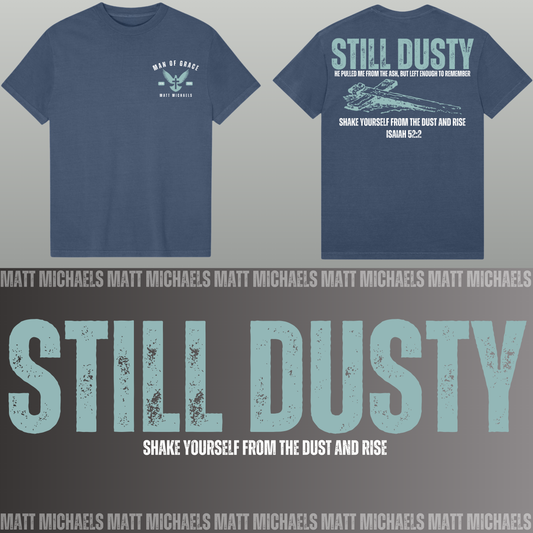 Navy blue t-shirt with 'Still Dusty' design on a gray background