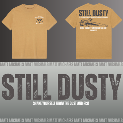 Yellow t-shirt with 'Still Dusty' design and branding on a gray background